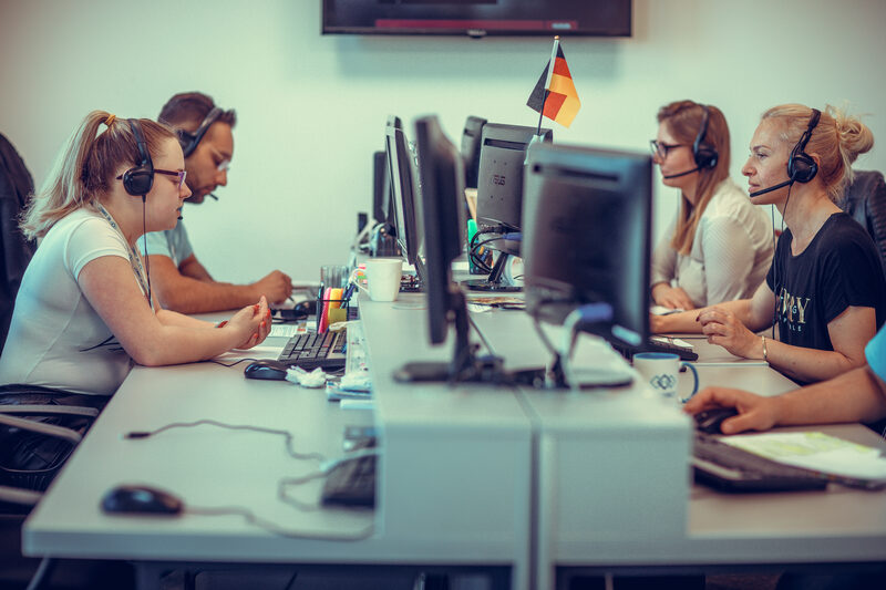 Tim We Connecta u kancelariji, agenti sa slušalicama za stolovima